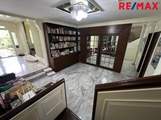 Spacious living room with bookshelves and marble flooring