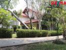 Two-story house with a red roof and lush garden