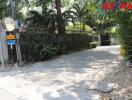 Driveway and entrance to a property with lush greenery