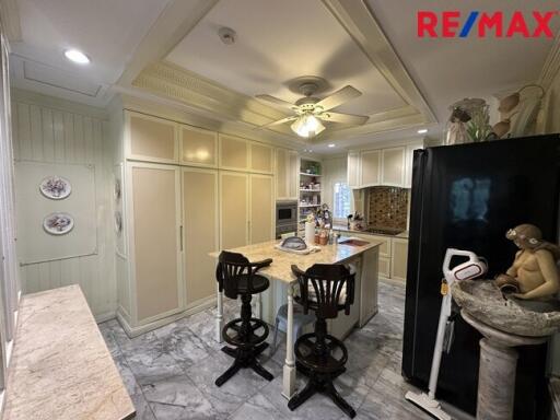 Modern white kitchen with marble countertops and center island