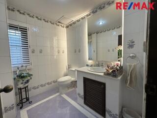 Bathroom with tiled walls and floor, sink, and toilet