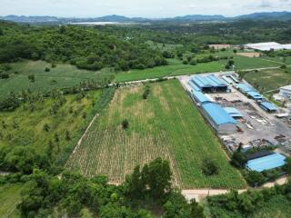 Aerial view of a large plot of agricultural land with nearby buildings