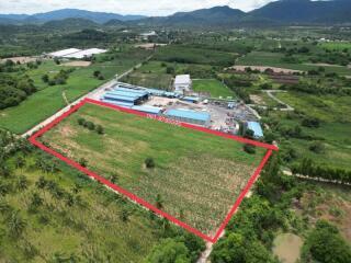 Aerial view of a large plot of land with a red boundary line