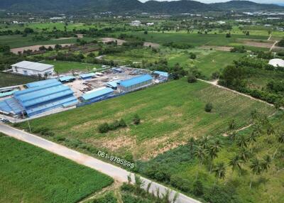 Aerial view of expansive green farmland with structures