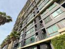 Exterior view of a modern multi-story apartment building with large windows and balconies