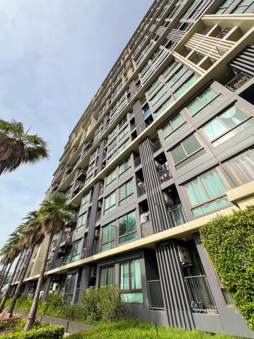 Exterior view of a modern multi-story apartment building with large windows and balconies