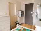 Small kitchen area with storage cabinets, refrigerator, and a door leading to another room