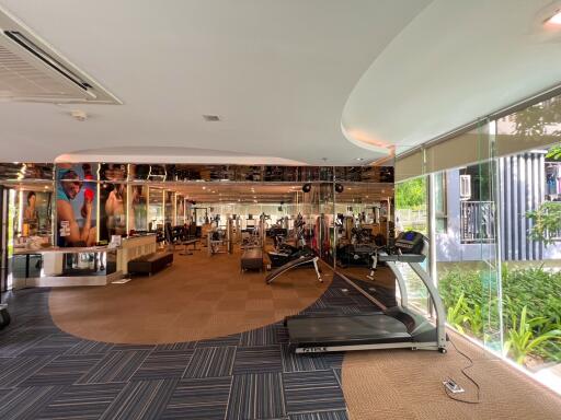 Spacious gym with various exercise equipment and large mirrors