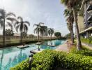 Swimming pool area with palm trees and construction crane in the background