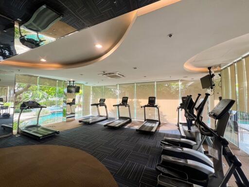 Modern gym with various exercise equipment and large windows