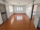 Empty bedroom with wooden floor and windows