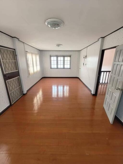 Empty bedroom with wooden floor and windows