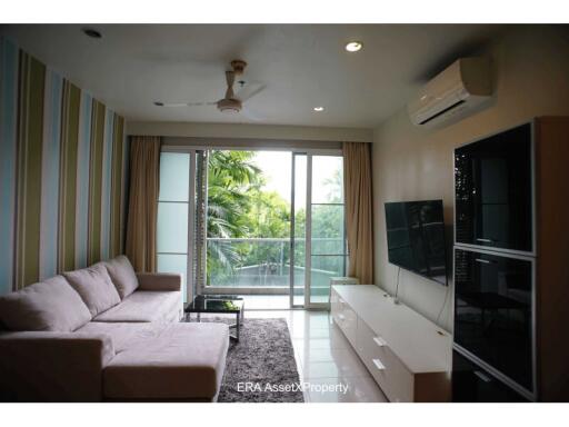 Modern living room with sofa, TV, and large windows