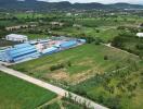 Aerial view of expansive agricultural land with nearby industrial buildings