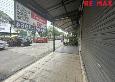 Photo of the exterior view of a commercial building with parked cars and signage.