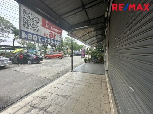 Photo of the exterior view of a commercial building with parked cars and signage.