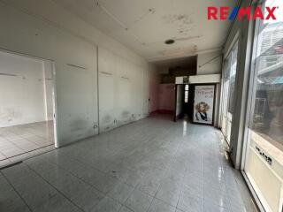 Empty commercial space with tiled flooring and large windows