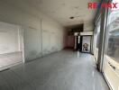 Empty commercial space with tiled flooring and large windows