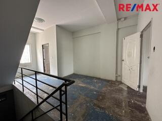 Unfurnished room with stair railing and door