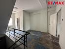 Unfurnished room with stair railing and door