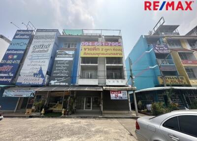 Exterior view of a commercial building with multiple units and advertisements