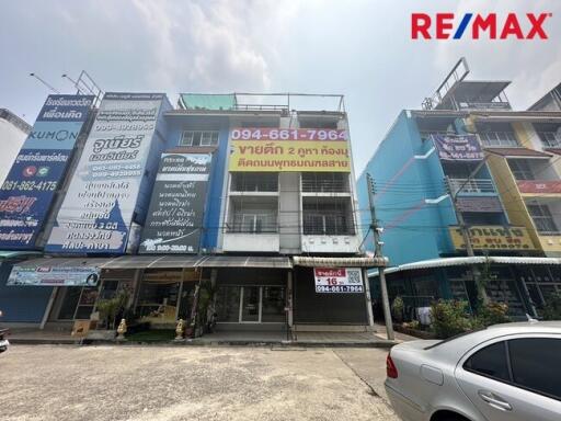 Exterior view of a commercial building with multiple units and advertisements