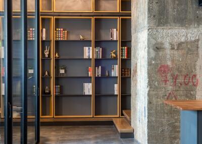 Modern living room with built-in bookshelves and concrete pillar