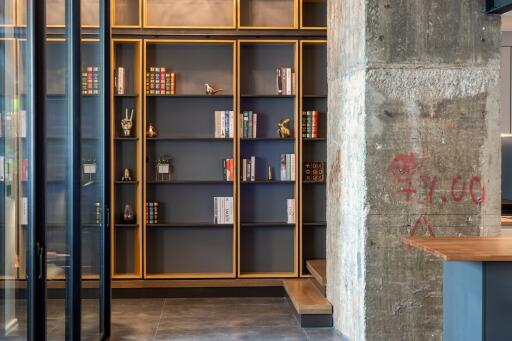 Modern living room with built-in bookshelves and concrete pillar