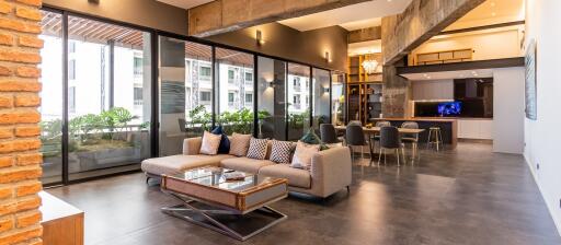 Modern open-plan living room and dining area with large windows and balcony.