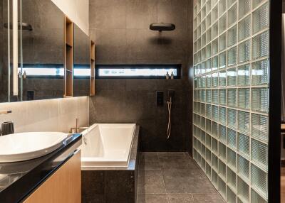 Modern bathroom with bathtub and glass block wall