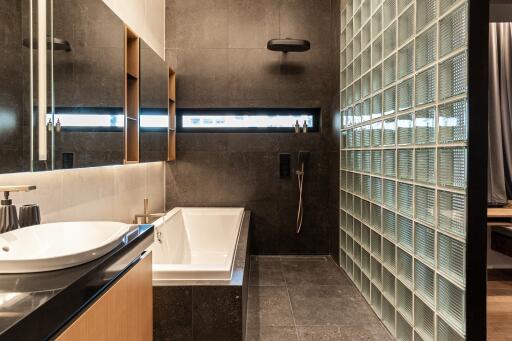 Modern bathroom with bathtub and glass block wall