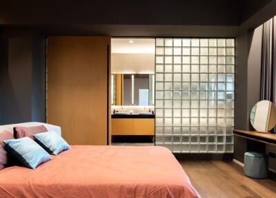 Modern bedroom with glass block partition and ensuite bathroom