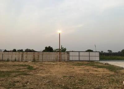 Empty lot with wooden fence and lamp post