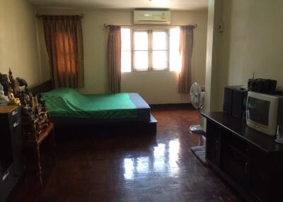 Bedroom with bed, window, air conditioner, and television