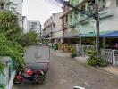 Street view of residential area with parked vehicles and townhouse buildings