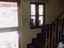 Entryway with staircase and a door with ornate iron grill