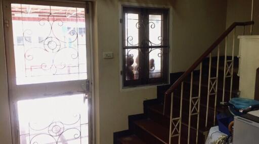 Entryway with staircase and a door with ornate iron grill