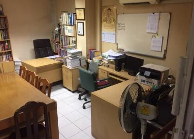Office space with desks, chairs, bookshelves, and a whiteboard