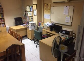 Office space with desks, chairs, bookshelves, and a whiteboard