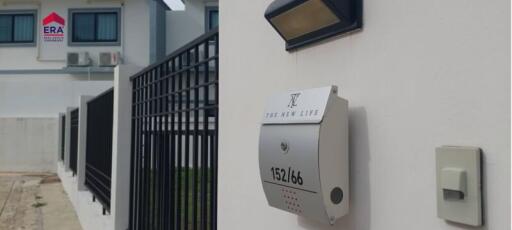 Exterior view of a modern house with fence and mailbox