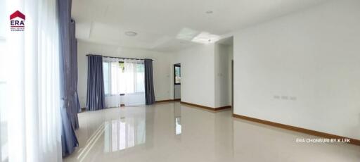 Spacious living room with large windows and curtains