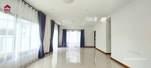 Spacious living room with large windows and curtains