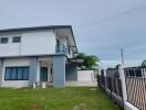 Modern two-story house exterior with green lawn