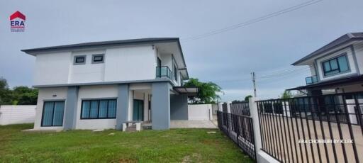 Modern two-story house exterior with green lawn