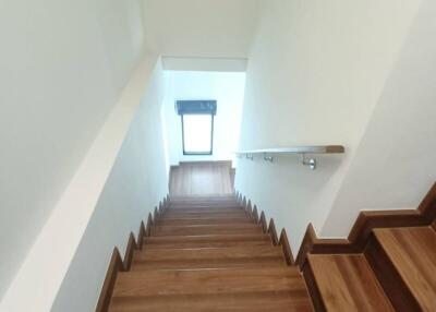 Wooden staircase with white walls and handrail