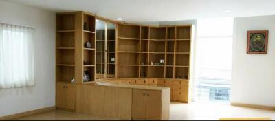 Living room with wooden built-in shelves and cabinets