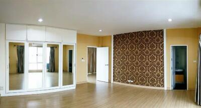 Spacious bedroom with mirrored closets and an accent wall