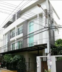 Modern multi-story building with balconies and lush greenery