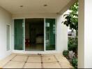 Covered patio area with sliding glass doors and greenery