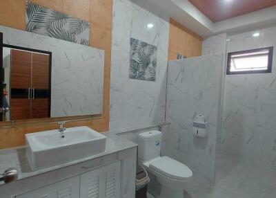 Modern bathroom with white marble walls and wooden ceiling finish